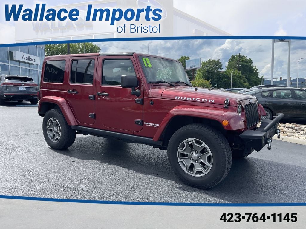 2013 Jeep Wrangler Unlimited Rubicon in Deep Cherry Red Crystal Pearlcoat — front three-quarter view